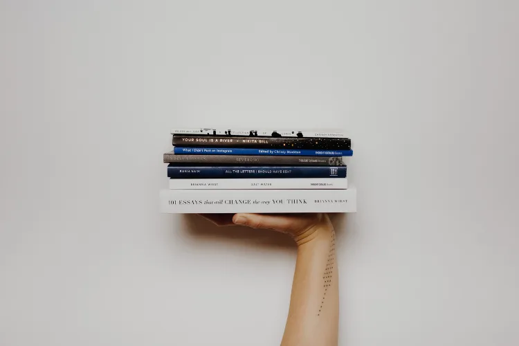 Stack of business books for entrepreneurs including titles on leadership and profitability