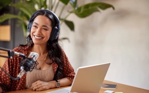 Entrepreneur recording a podcast interview with Virtual Assistant handling outreach and scheduling