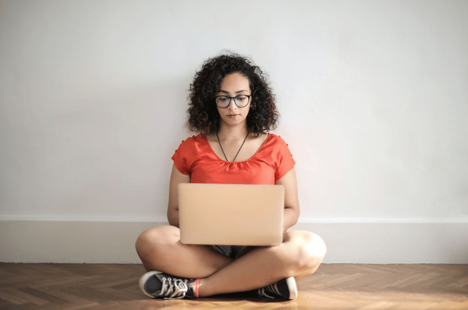 Woman sitting with laptop researching frequently asked questions about virtual assistants