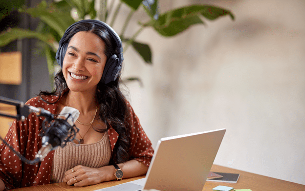 Entrepreneur recording a podcast interview with virtual assistant handling outreach and scheduling