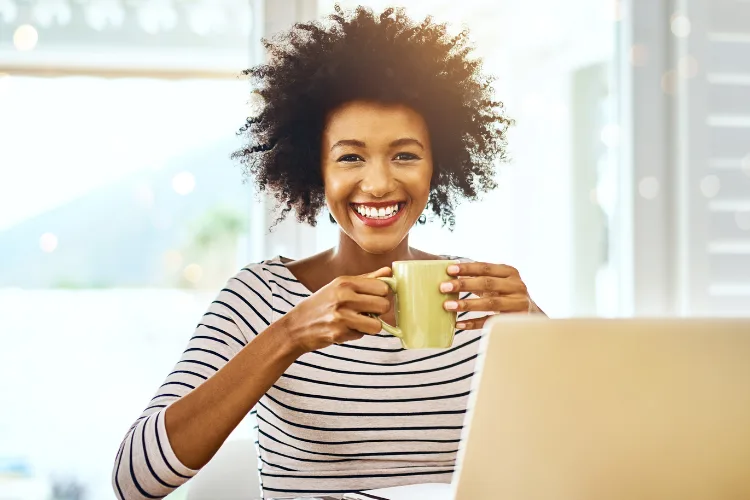 Happy woman smiling while working remotely on laptop as a virtual assistant from home
